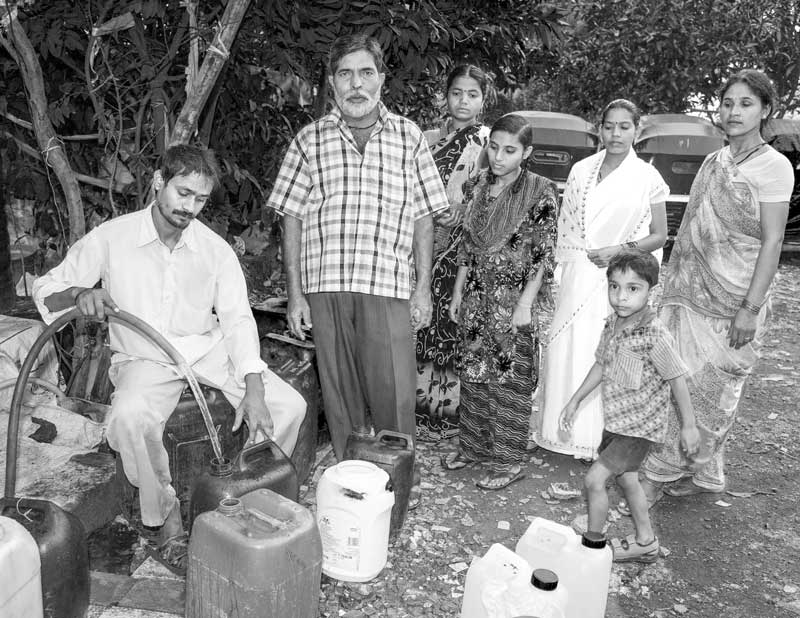 Water 'hijacked' from a group connection in a slum being sold for profit in Mumbai